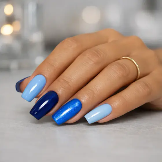 Uñas cuadradas azules con una uña de efecto espejo